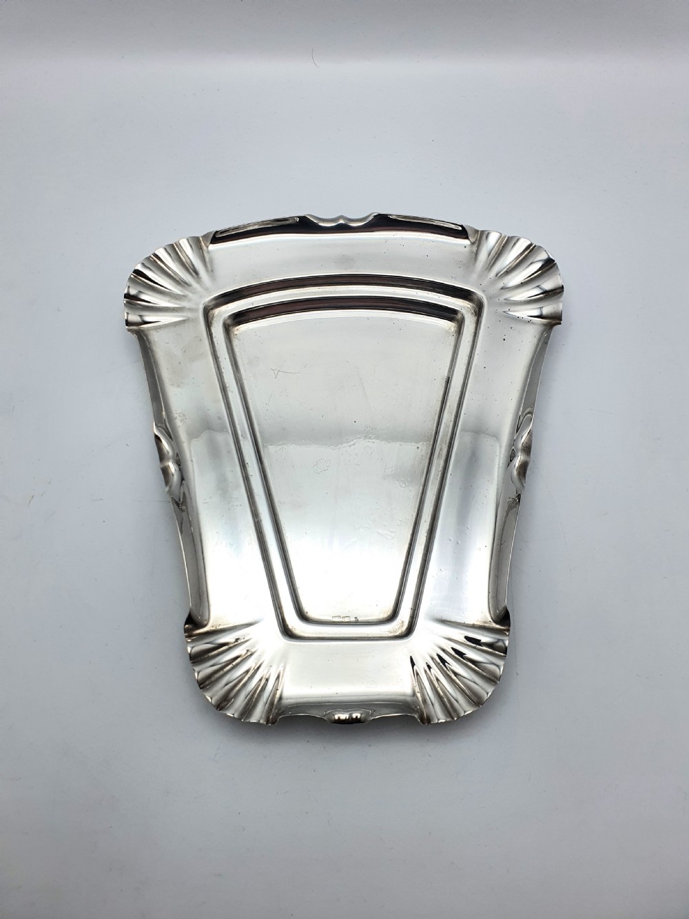 A wedge-shaped glass cheese dome with etched botanical details resting on a contoured silver-plated tray. View IX