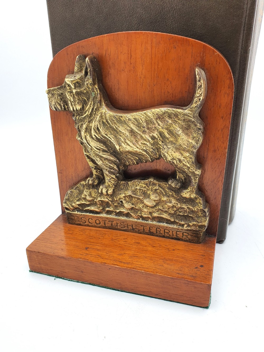 A pair of vintage 1930s wooden bookends featuring detailed cast brass reliefs of Scottish Terriers mounted on the front. View II