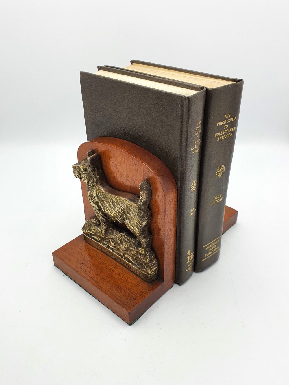 A pair of vintage 1930s wooden bookends featuring detailed cast brass reliefs of Scottish Terriers mounted on the front. View III