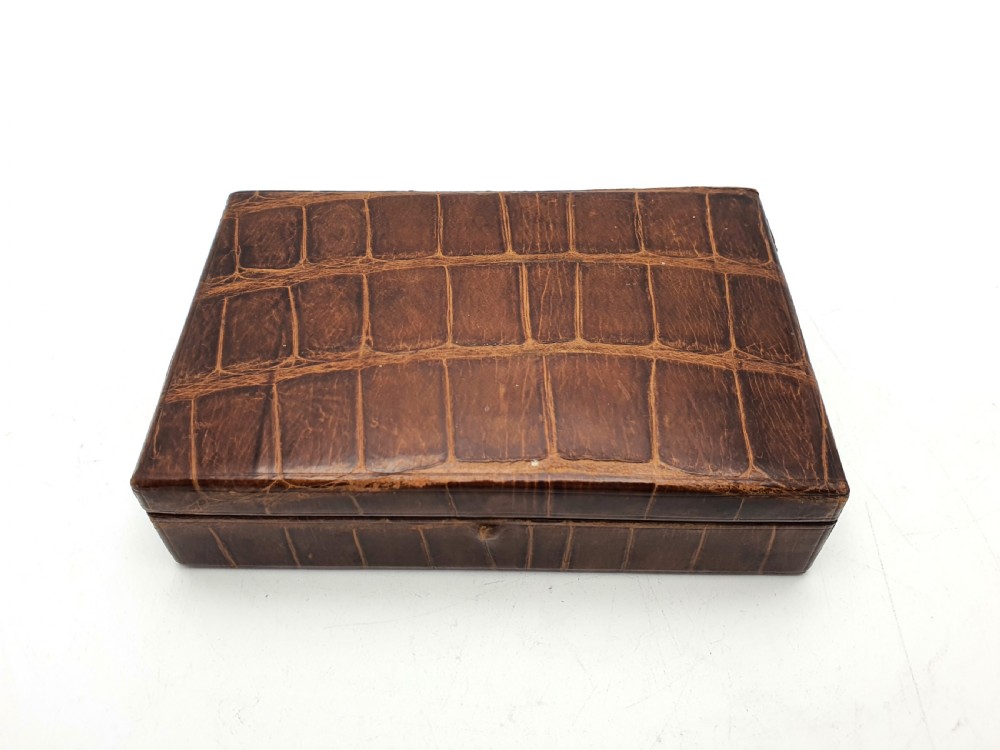 A rectangular 1920s jewellery box covered in polished chestnut brown crocodile skin with distinct natural scale patterning.