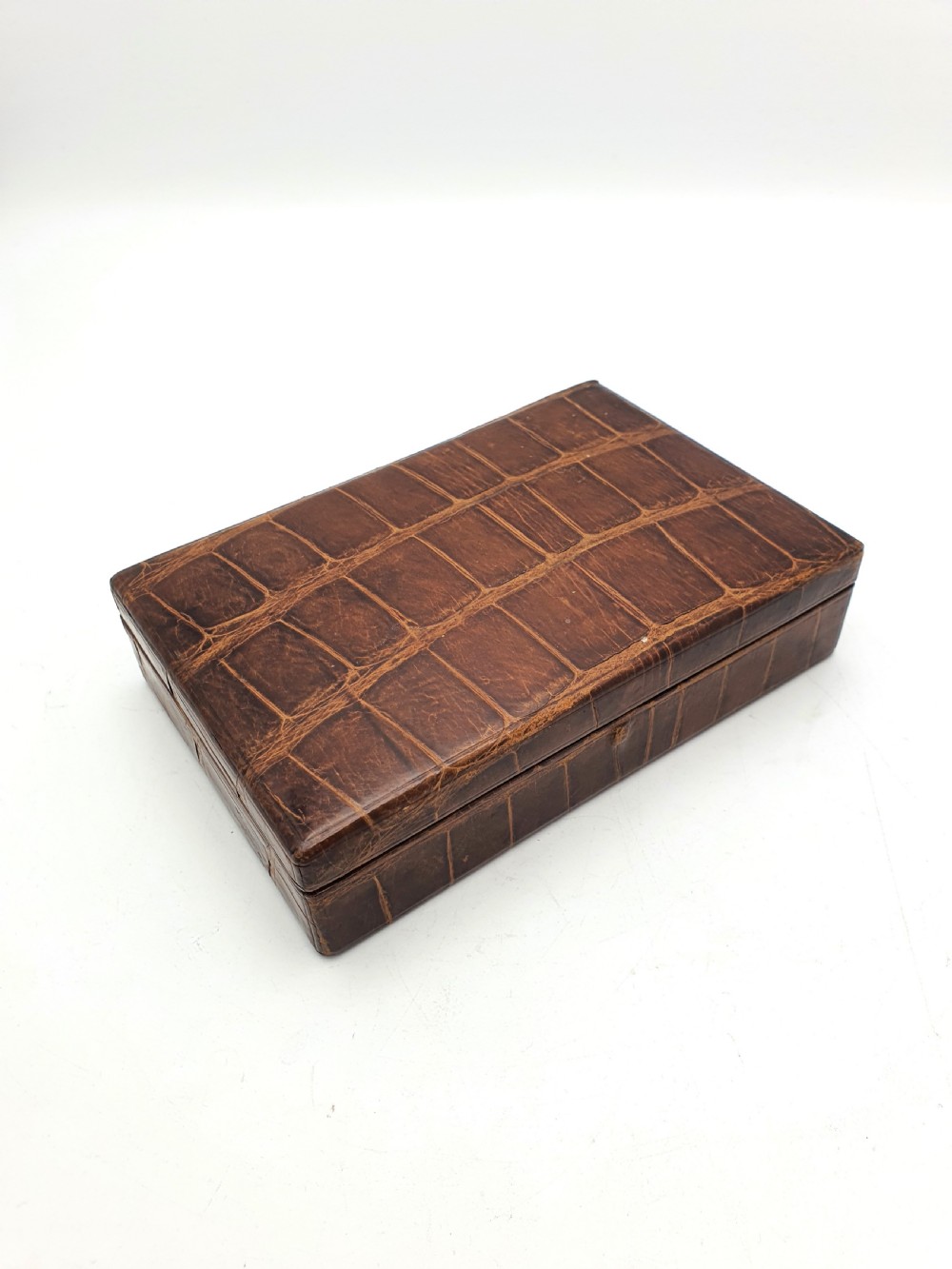 A rectangular 1920s jewellery box covered in polished chestnut brown crocodile skin with distinct natural scale patterning. View II