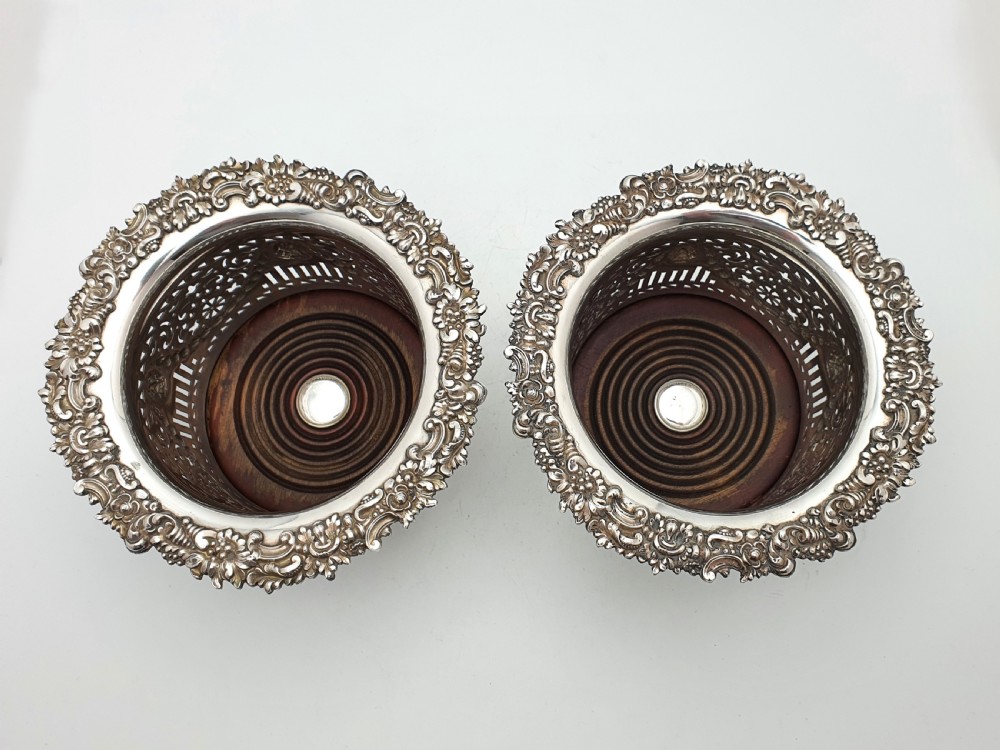 A pair of circular silver-plated wine coasters with pierced fretwork sides, garland swags, medallion motifs, and decorative rims. View III
