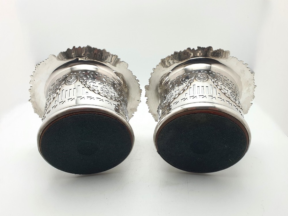 A pair of circular silver-plated wine coasters with pierced fretwork sides, garland swags, medallion motifs, and decorative rims. View VI