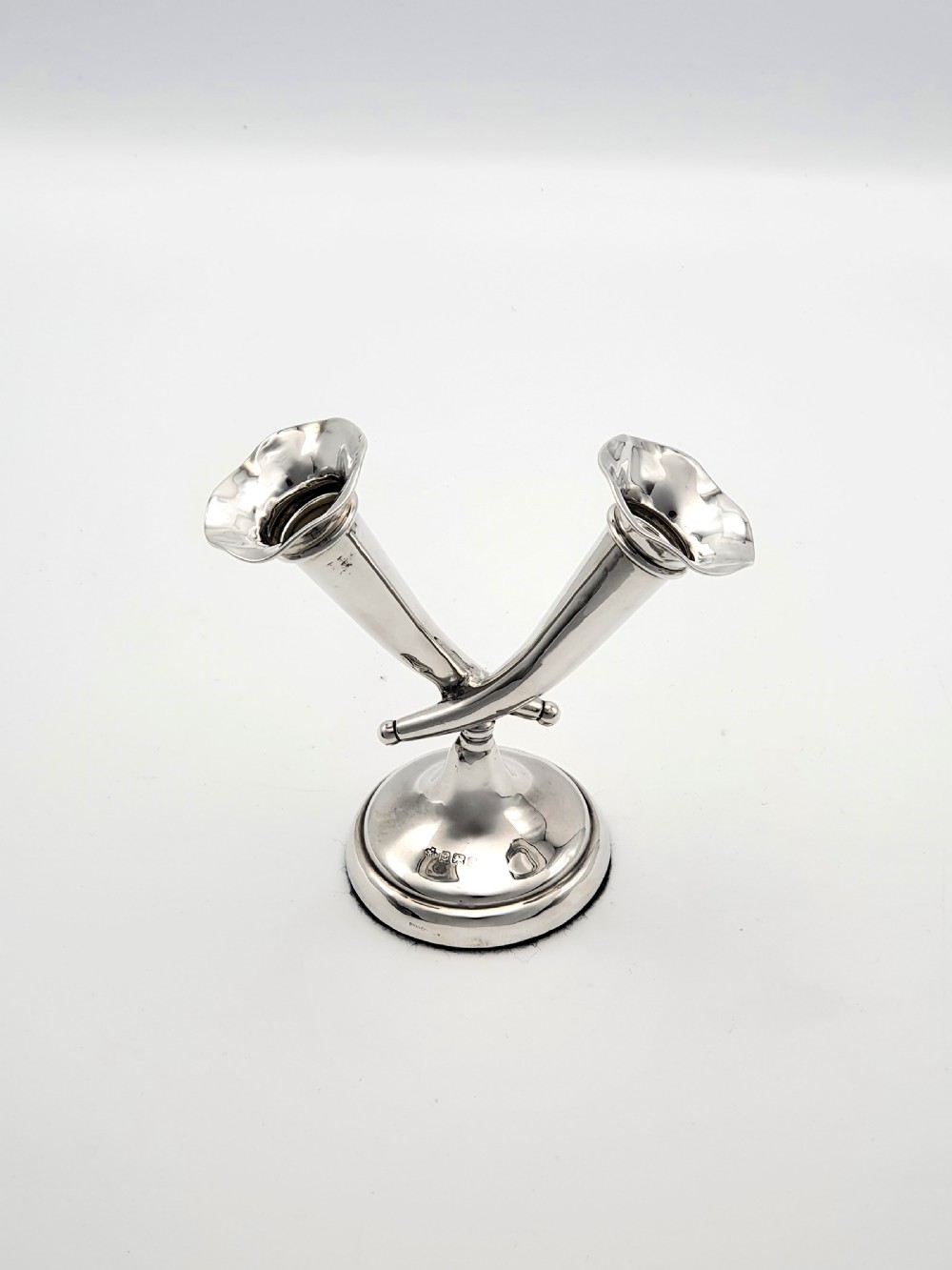 An Edwardian sterling silver twin epergne featuring two crossed trumpet-shaped fluted vases set upon a circular weighted base.