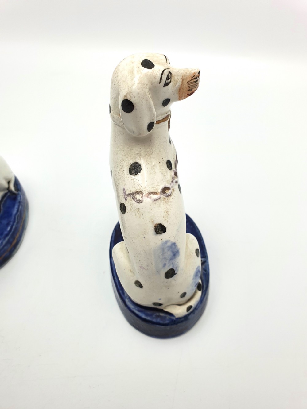 A pair of late Victorian Staffordshire earthenware figures depicting seated Dalmatians with hand-painted black spots on cobalt blue bases. View VII