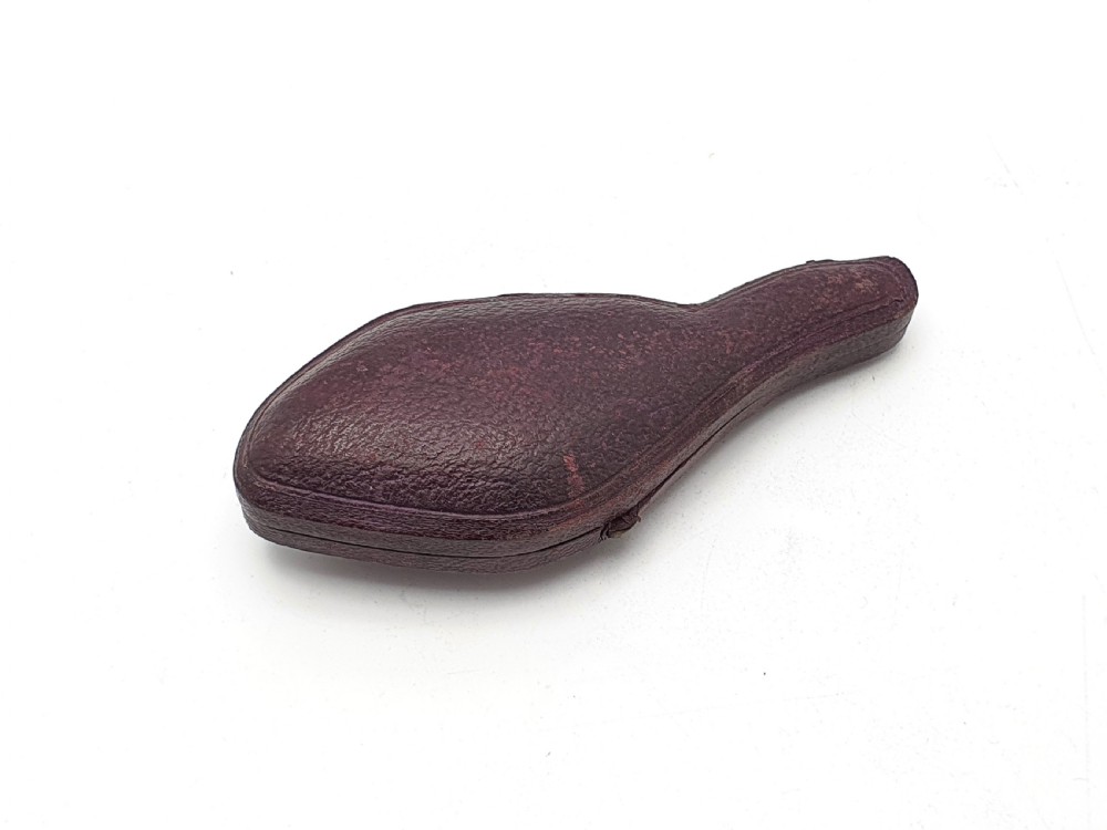 An antique carved meerschaum cheroot holder featuring detailed hunting dogs resting inside a green velvet-lined fitted case. View VI