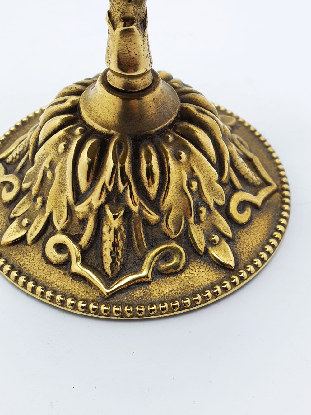 A silver-plated dome desk bell with a brass plunger mechanism mounted on an ornate circular brass base decorated with acanthus leaf motifs. View III