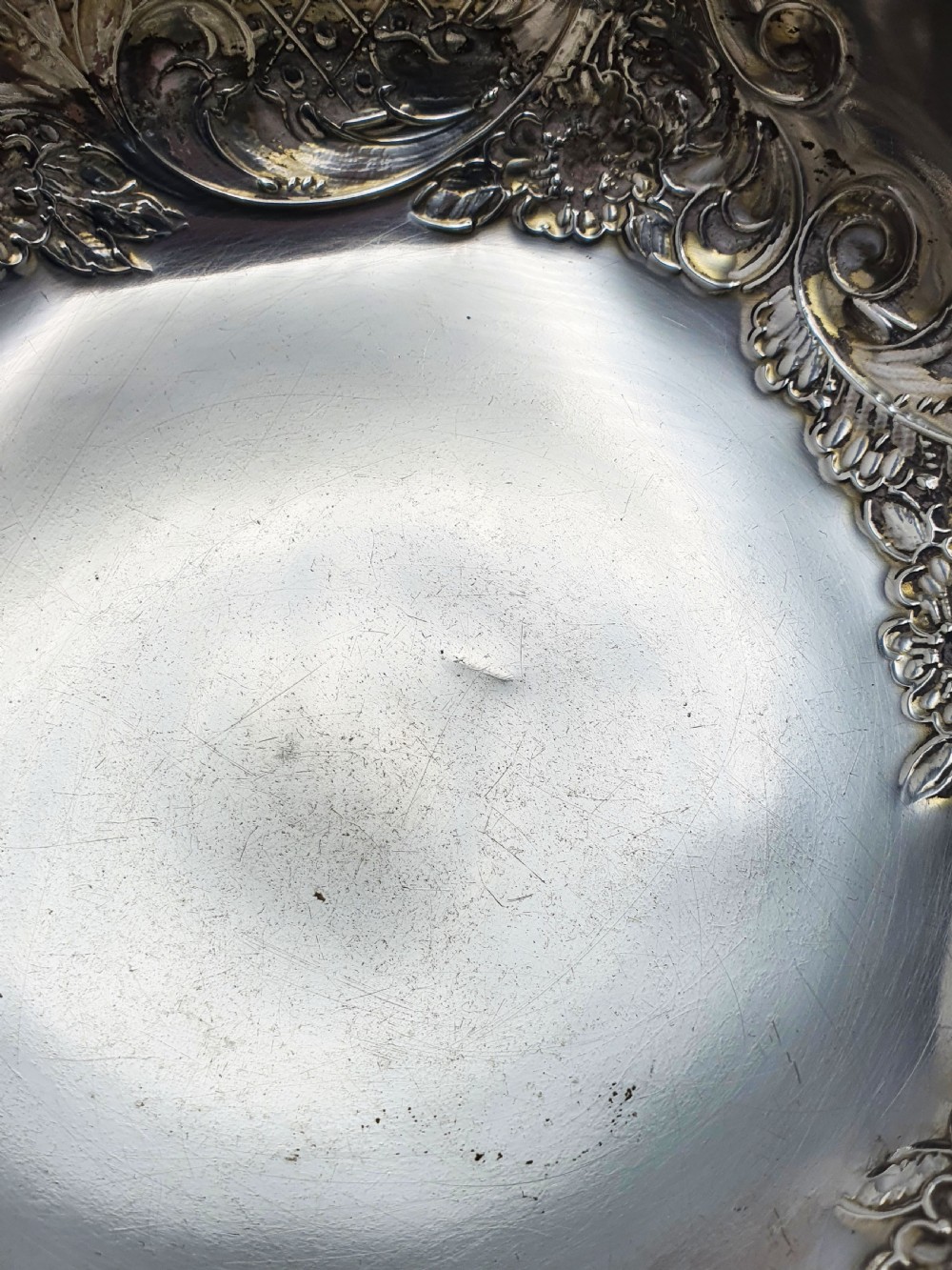 A circular Victorian sterling silver bowl featuring ornate repousse floral chasing, a crimped fluted rim, and a raised pedestal foot. View IX