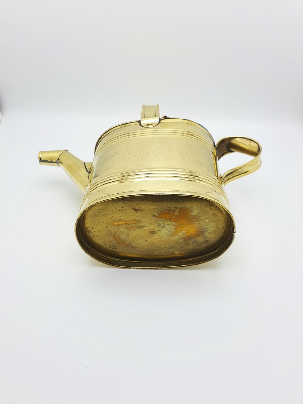 A polished late Victorian brass watering can with an oval body, a curved upper bridge handle, a rear loop handle, and a straight tapered spout. View VIII
