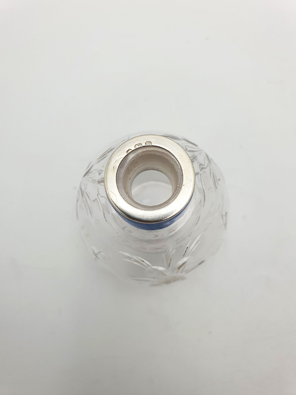 A clear cut glass scent bottle featuring a bright blue guilloche enamel collar and matching octagonal stopper set in sterling silver. View VI