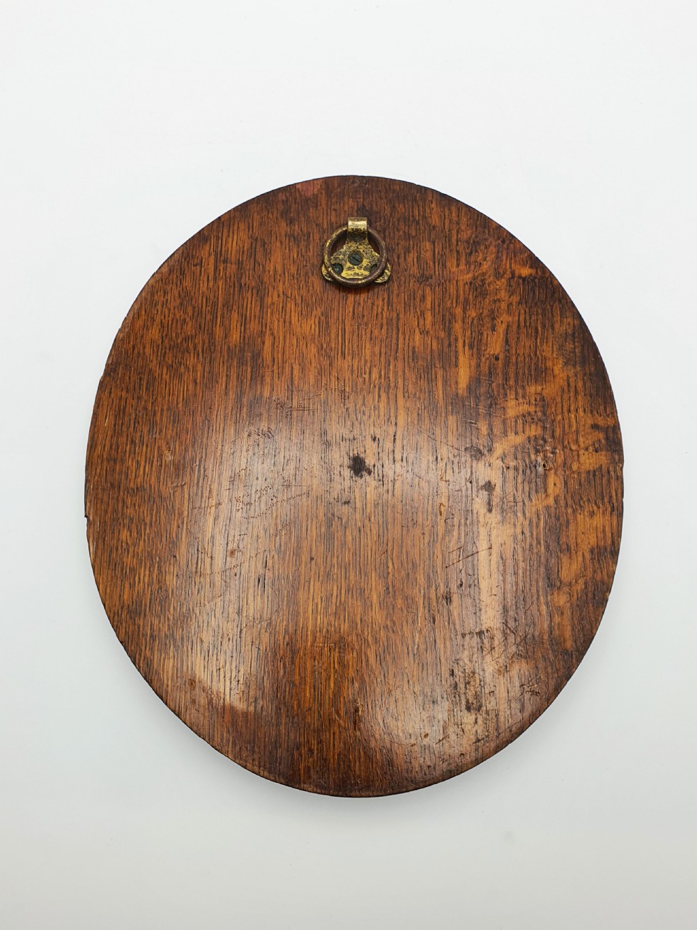 An oval timber plaque displaying an embossed silver-plated metal relief depiction of late Victorian lawn bowling players dated 1899. View V
