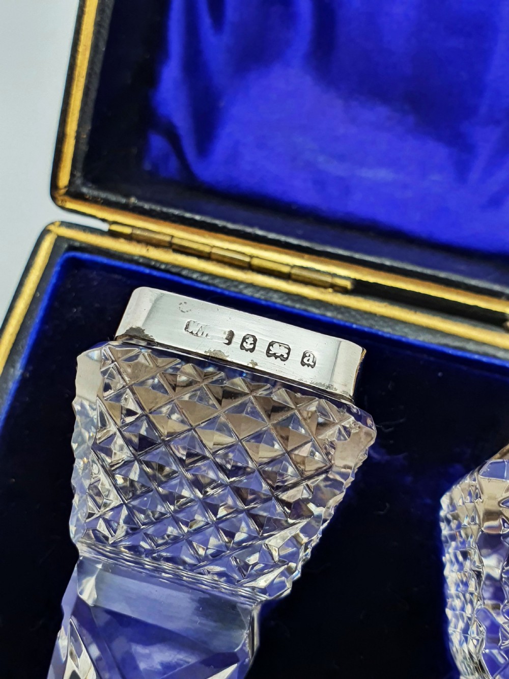 A pair of cut glass knife rests with hallmarked silver end caps housed in a dark blue velvet-lined fitted presentation case. View III