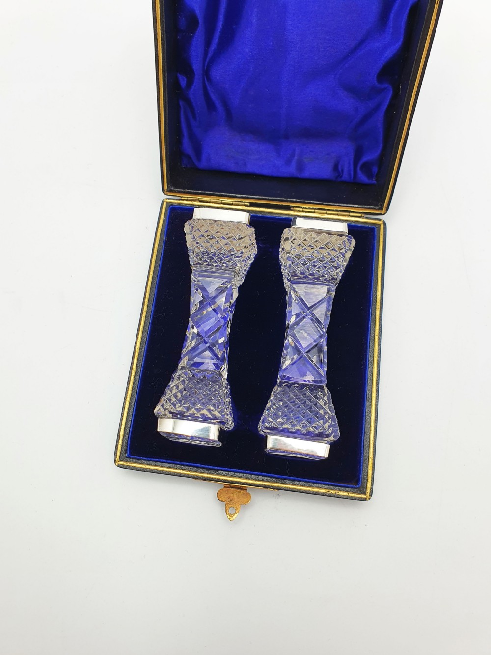 A pair of cut glass knife rests with hallmarked silver end caps housed in a dark blue velvet-lined fitted presentation case. View V