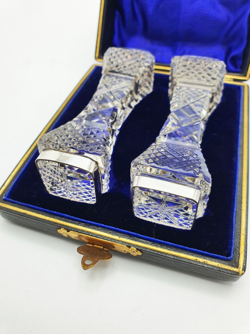 A pair of cut glass knife rests with hallmarked silver end caps housed in a dark blue velvet-lined fitted presentation case. View VI