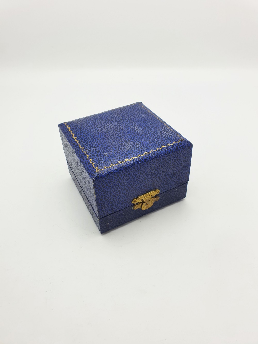 An Edwardian sterling silver napkin ring featuring intricate pierced leaf motifs and an unengraved central oval cartouche, presented in a velvet-lined blue box. View VI