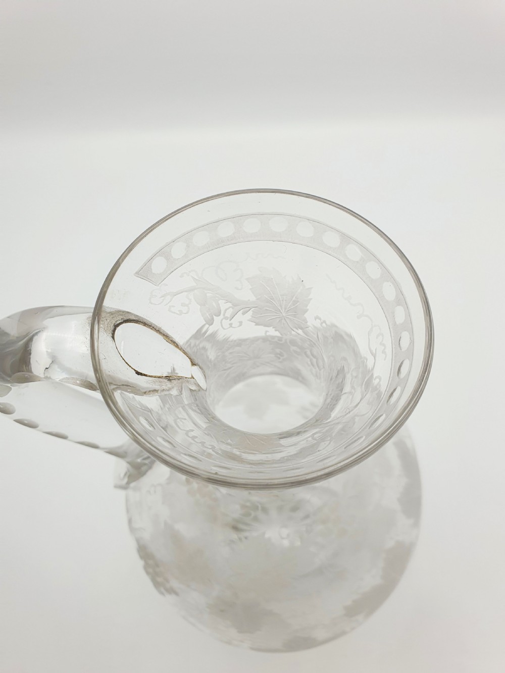 A late 19th-century clear glass wine jug decorated with etched grapevine motifs, a flared rim, and a curved applied handle. View III