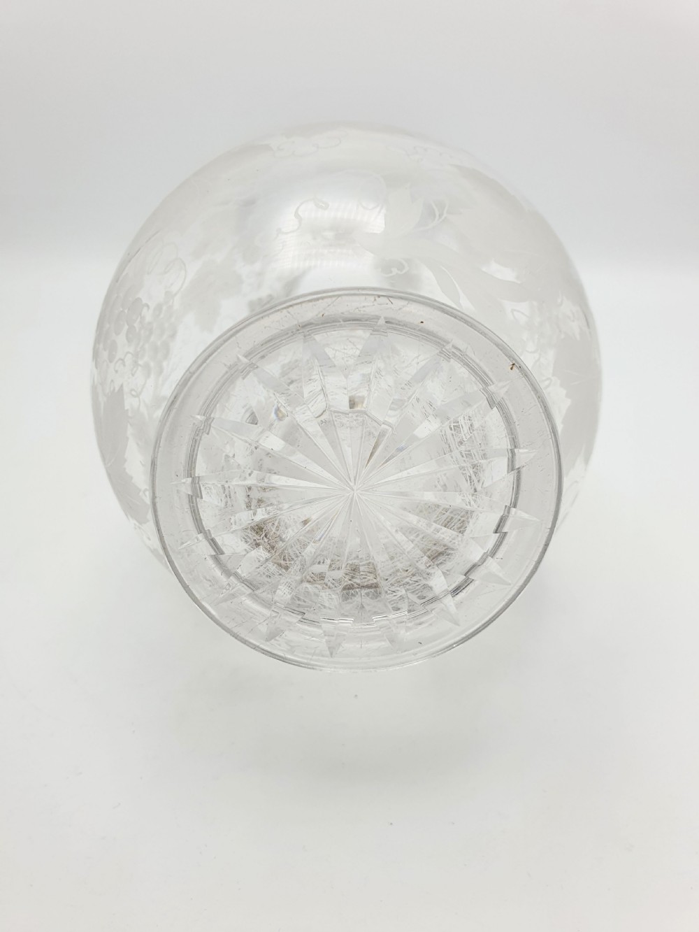 A late 19th-century clear glass wine jug decorated with etched grapevine motifs, a flared rim, and a curved applied handle. View VII