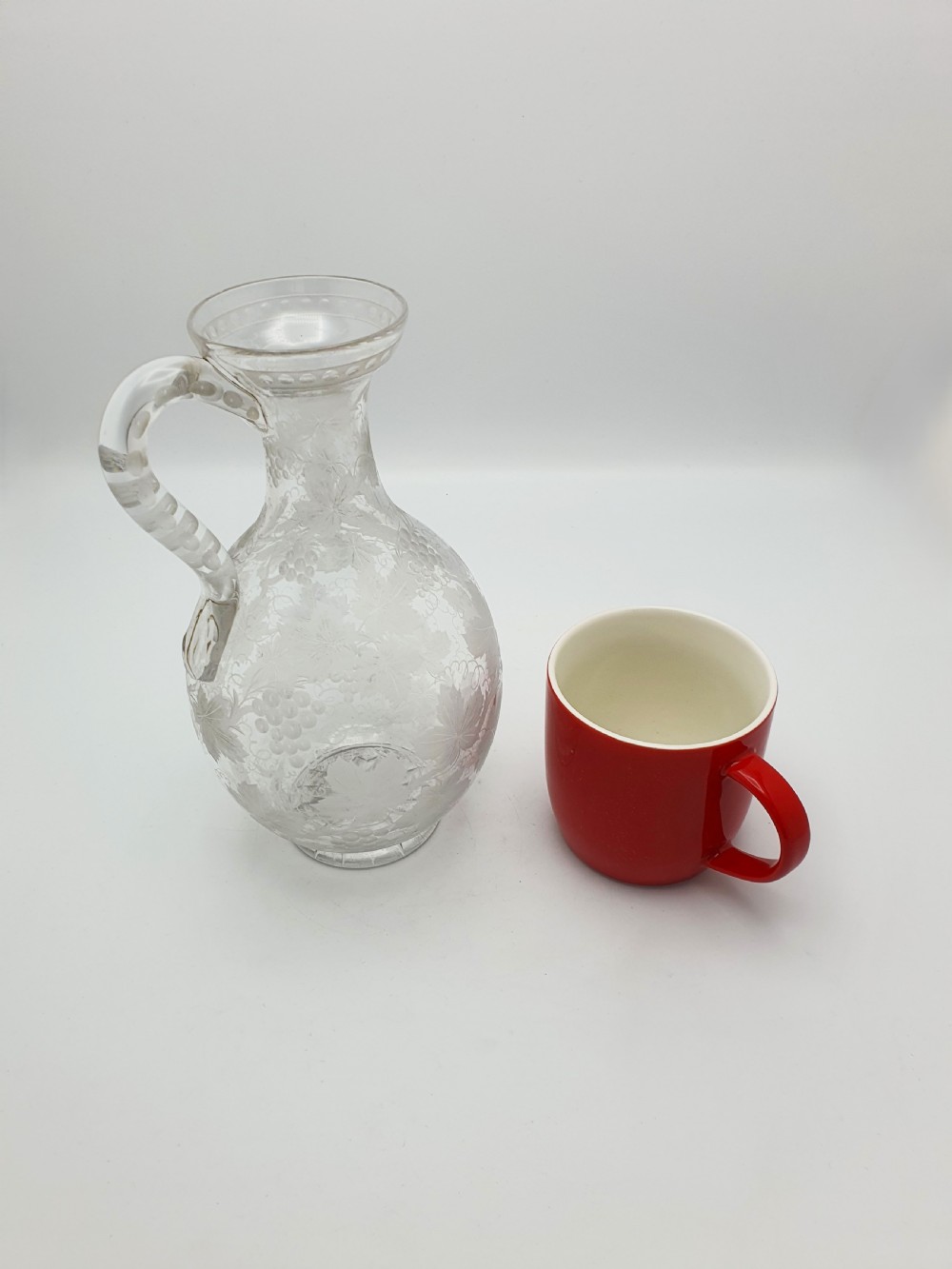A late 19th-century clear glass wine jug decorated with etched grapevine motifs, a flared rim, and a curved applied handle. View VIII