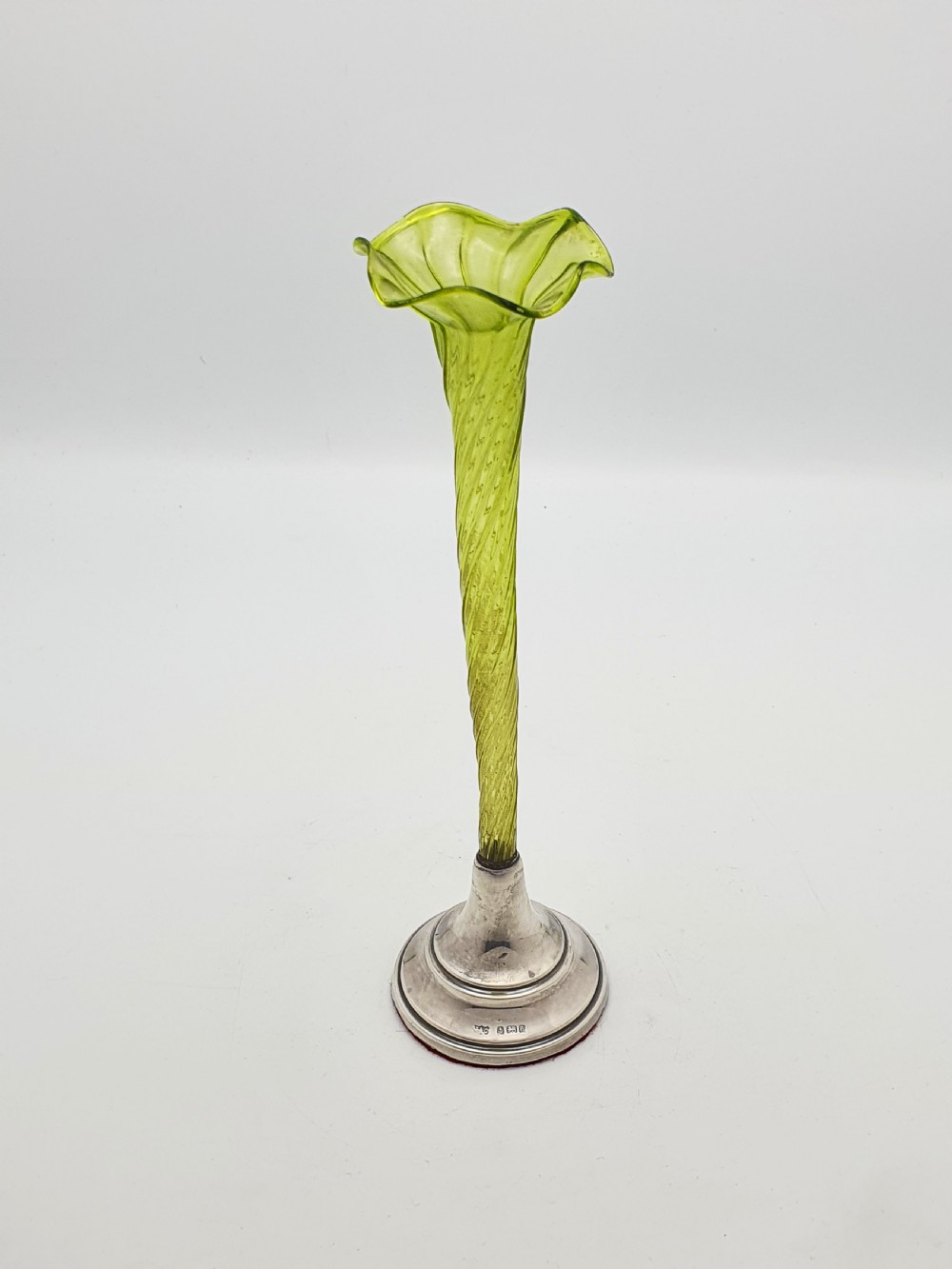An Edwardian green glass bud vase with a spiral stem and frilled rim, set into a circular hallmarked sterling silver base. View II