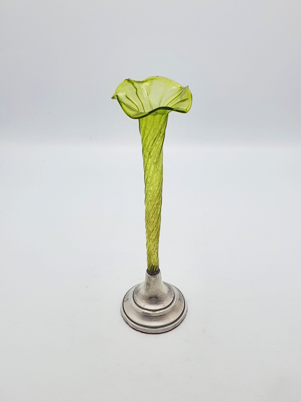 An Edwardian green glass bud vase with a spiral stem and frilled rim, set into a circular hallmarked sterling silver base. View III