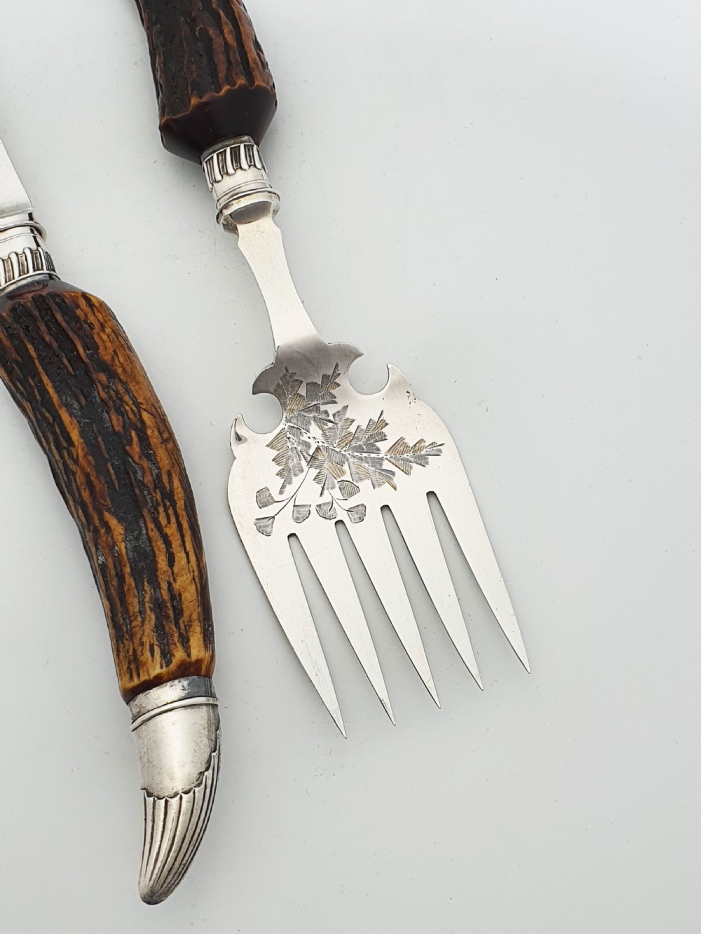 A pair of Victorian silver-plated fish servers with natural antler handles and engraved leaf patterns on the blade and fork. View II