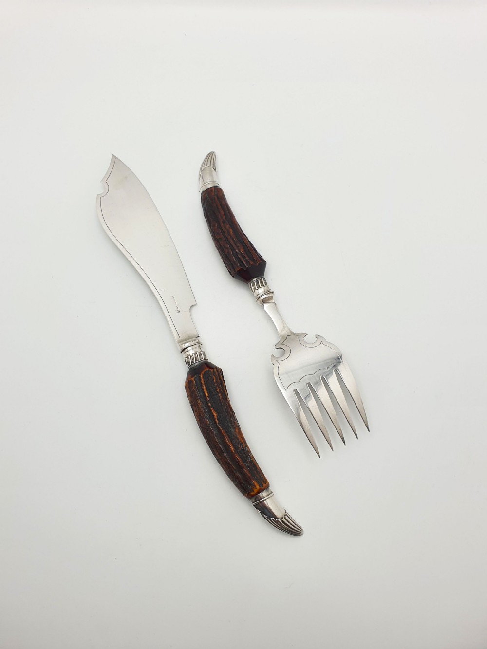 A pair of Victorian silver-plated fish servers with natural antler handles and engraved leaf patterns on the blade and fork. View V