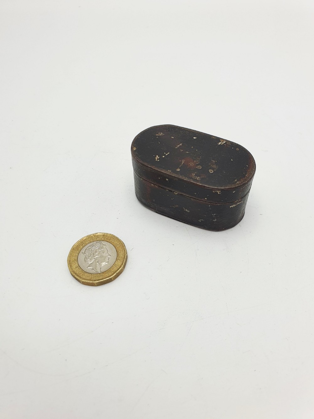 An open oval Georgian metal pocket nutmeg grater showing a hinged lid and a perforated grating surface with age patina. View V