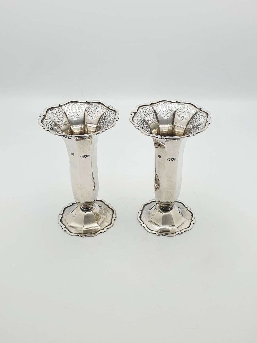 A pair of solid sterling silver trumpet vases featuring flared pierced rims with scroll details and octagonal stems.