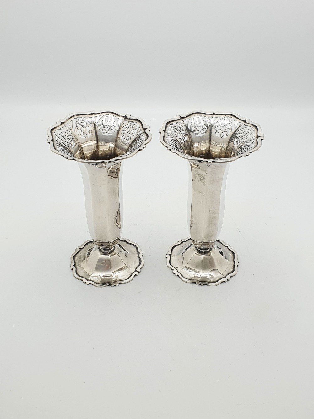 A pair of solid sterling silver trumpet vases featuring flared pierced rims with scroll details and octagonal stems. View II