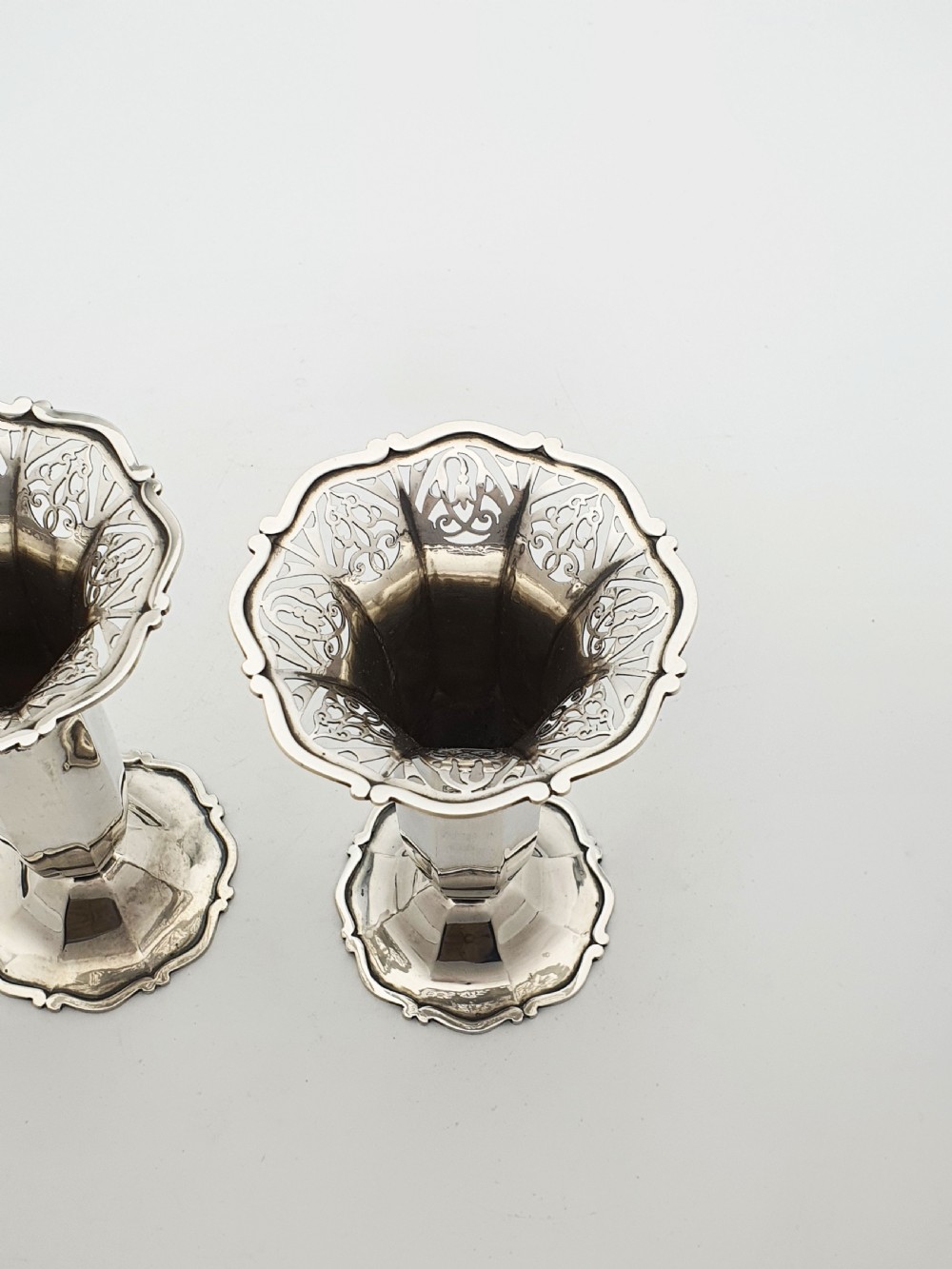 A pair of solid sterling silver trumpet vases featuring flared pierced rims with scroll details and octagonal stems. View III