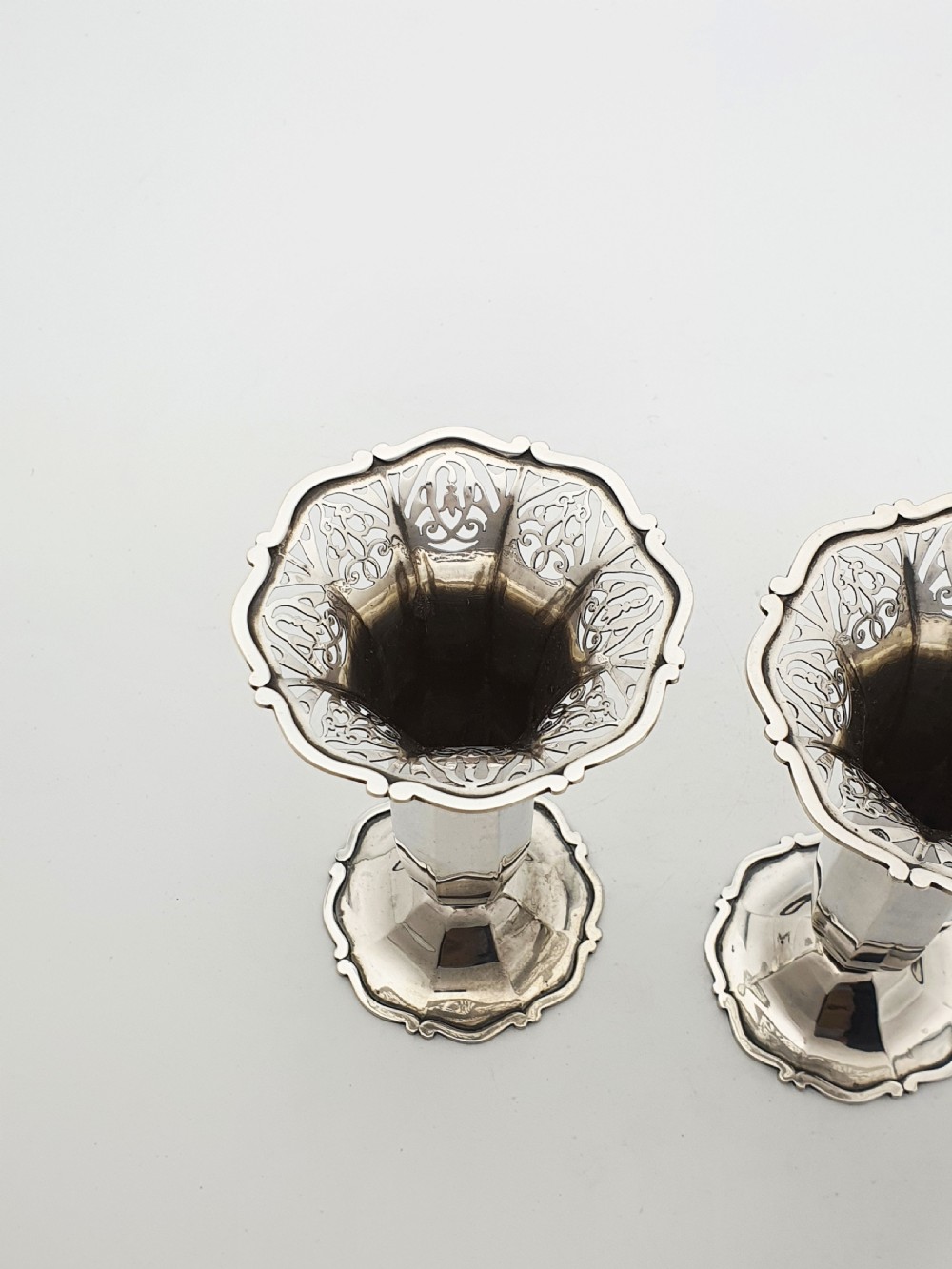 A pair of solid sterling silver trumpet vases featuring flared pierced rims with scroll details and octagonal stems. View V