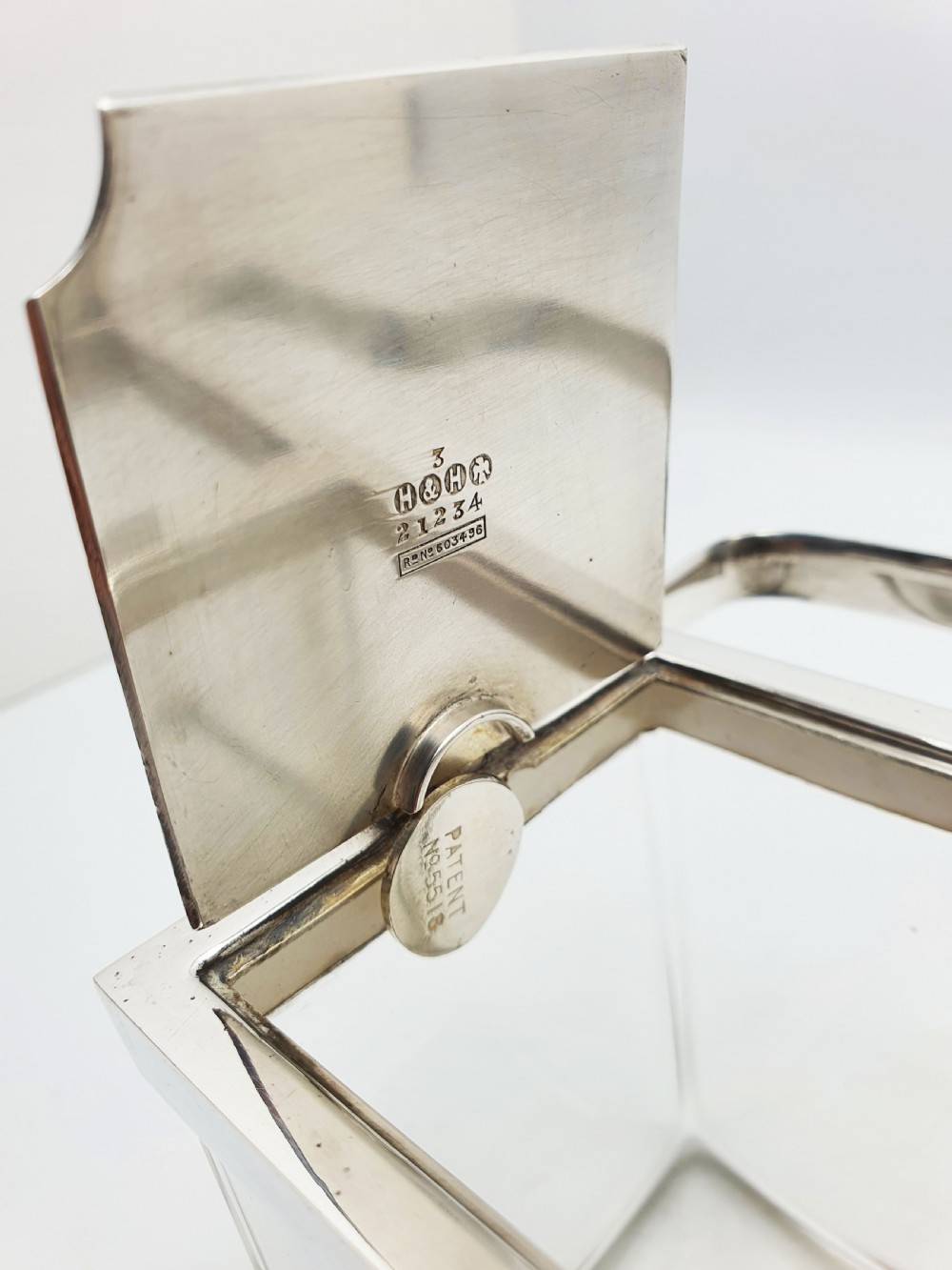 An antique silver-plated metal stand holding two clear rectangular glass jars with a central handle and mechanical lid system. View V