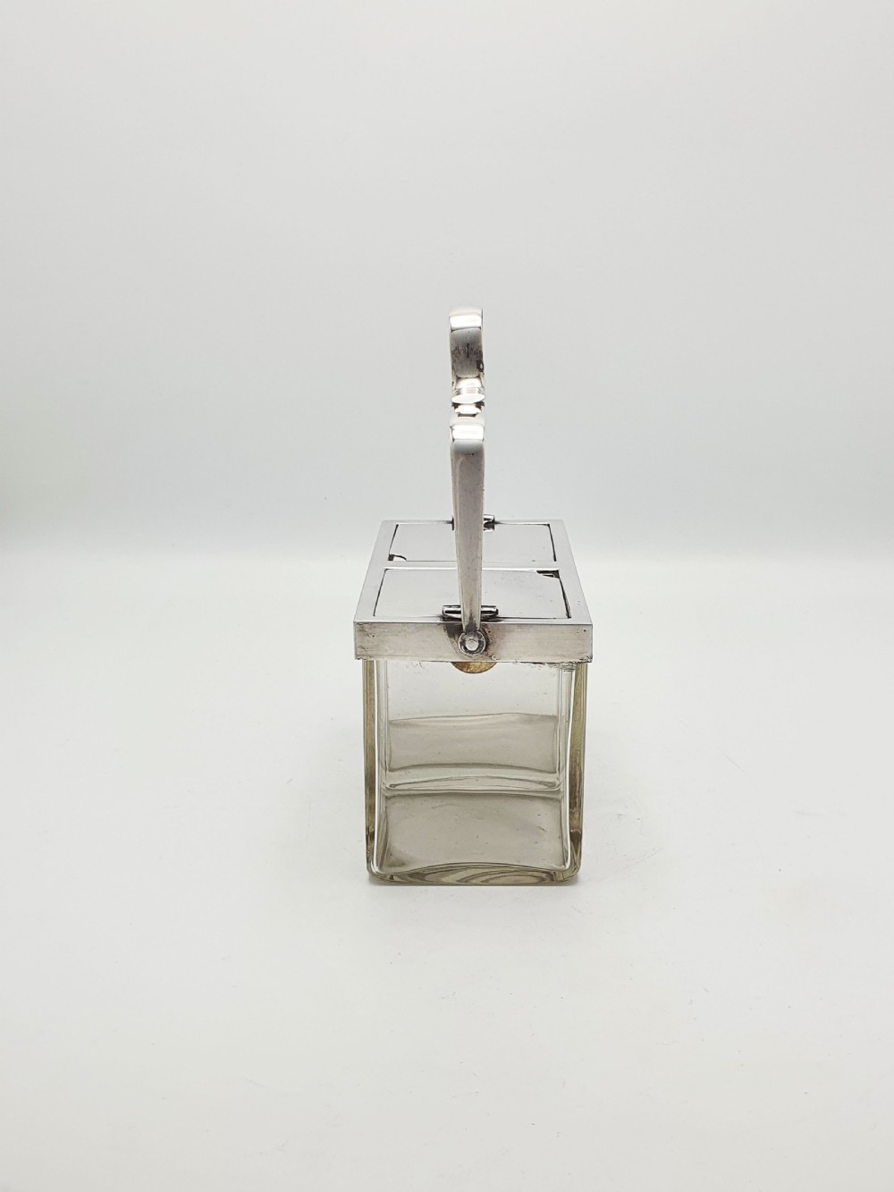 An antique silver-plated metal stand holding two clear rectangular glass jars with a central handle and mechanical lid system. View VI