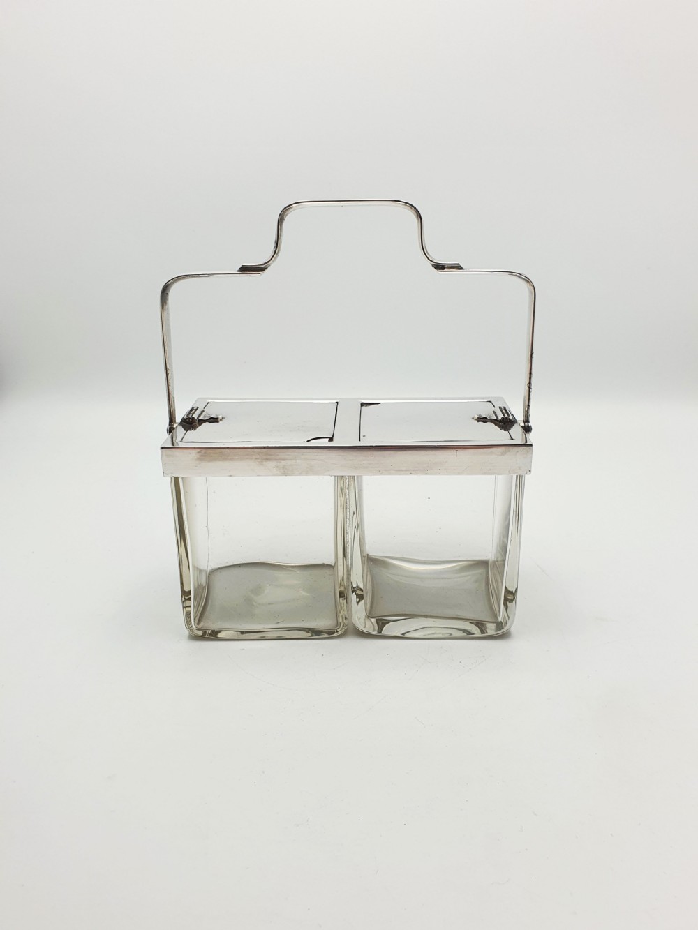 An antique silver-plated metal stand holding two clear rectangular glass jars with a central handle and mechanical lid system. View VIII