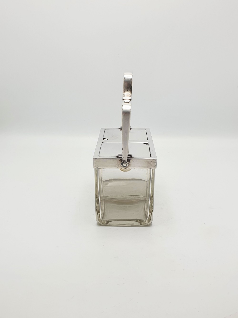 An antique silver-plated metal stand holding two clear rectangular glass jars with a central handle and mechanical lid system. View IX