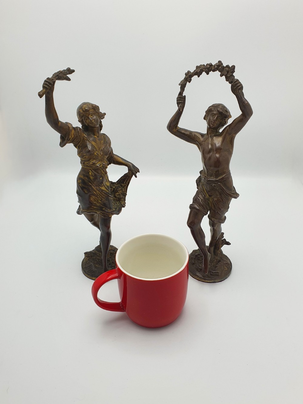 A pair of dark patinated bronze figurines depicting male and female harvest dancers holding floral garlands. View IX