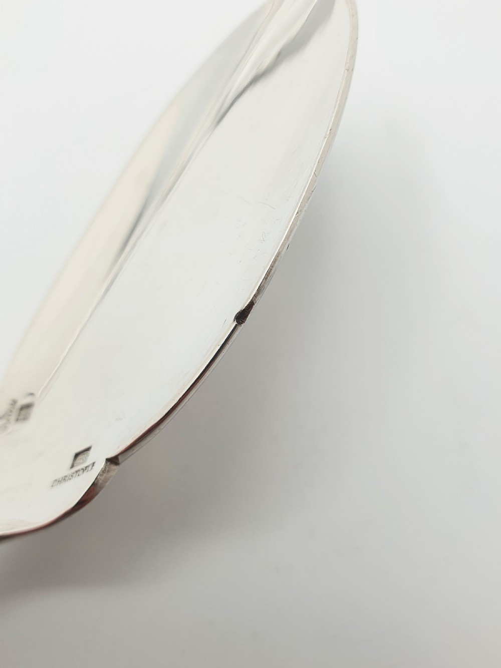 A set of eight French silver-plated dessert spoons arranged in a fan shape against a neutral background. View VI