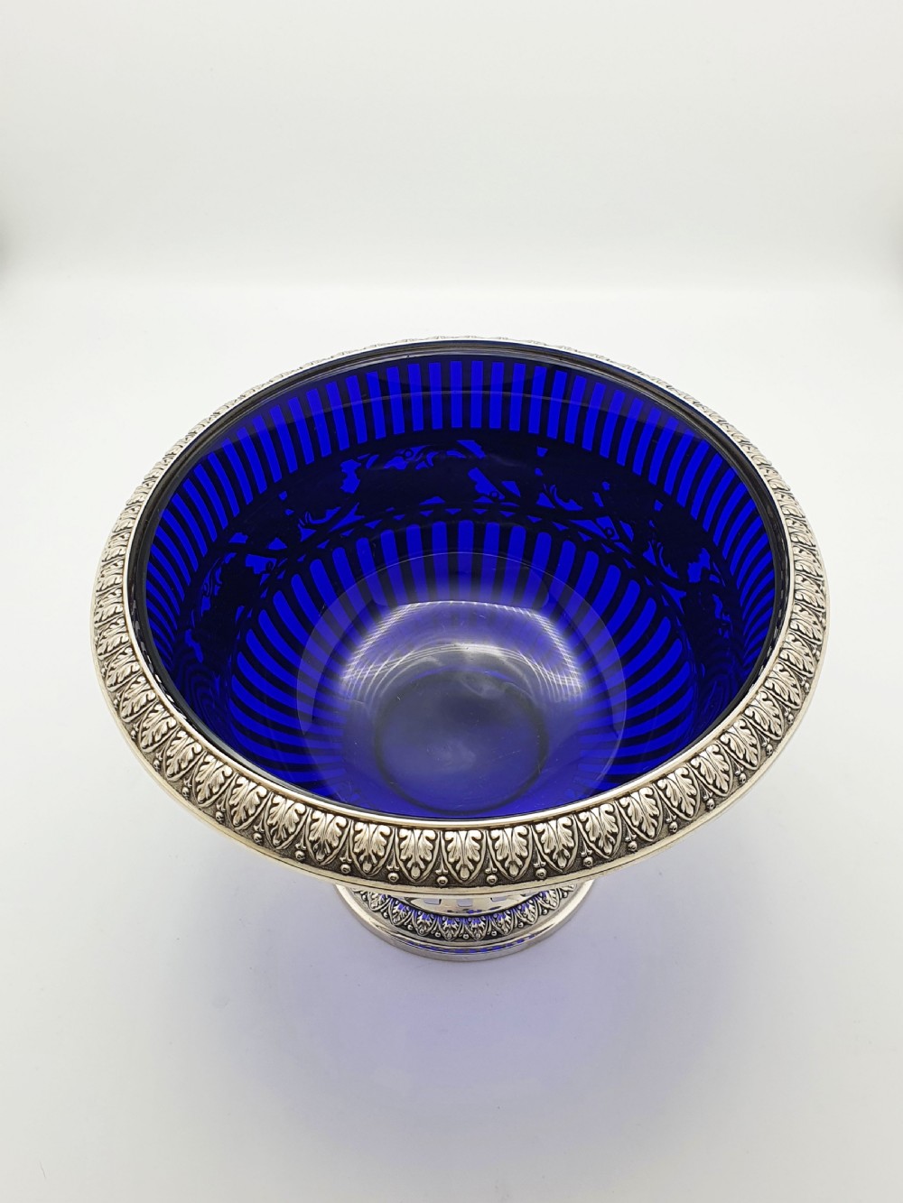 A German 800 silver centrepiece bowl featuring a pierced leaf and vine motif frame on a pedestal base with a cobalt blue glass liner. View III