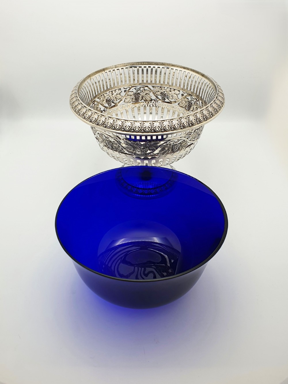 A German 800 silver centrepiece bowl featuring a pierced leaf and vine motif frame on a pedestal base with a cobalt blue glass liner. View VII