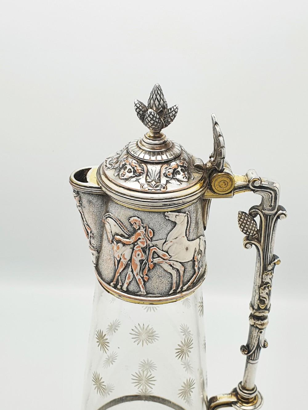 A tall Victorian silver-plated and etched glass claret jug featuring classical reliefs, a Greek key border, and star-cut engravings. View VI