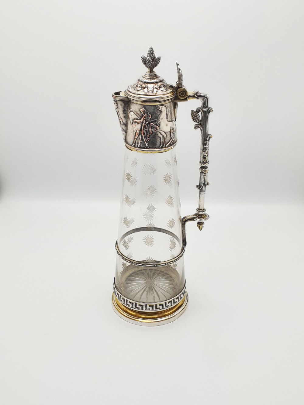 A tall Victorian silver-plated and etched glass claret jug featuring classical reliefs, a Greek key border, and star-cut engravings. View IX
