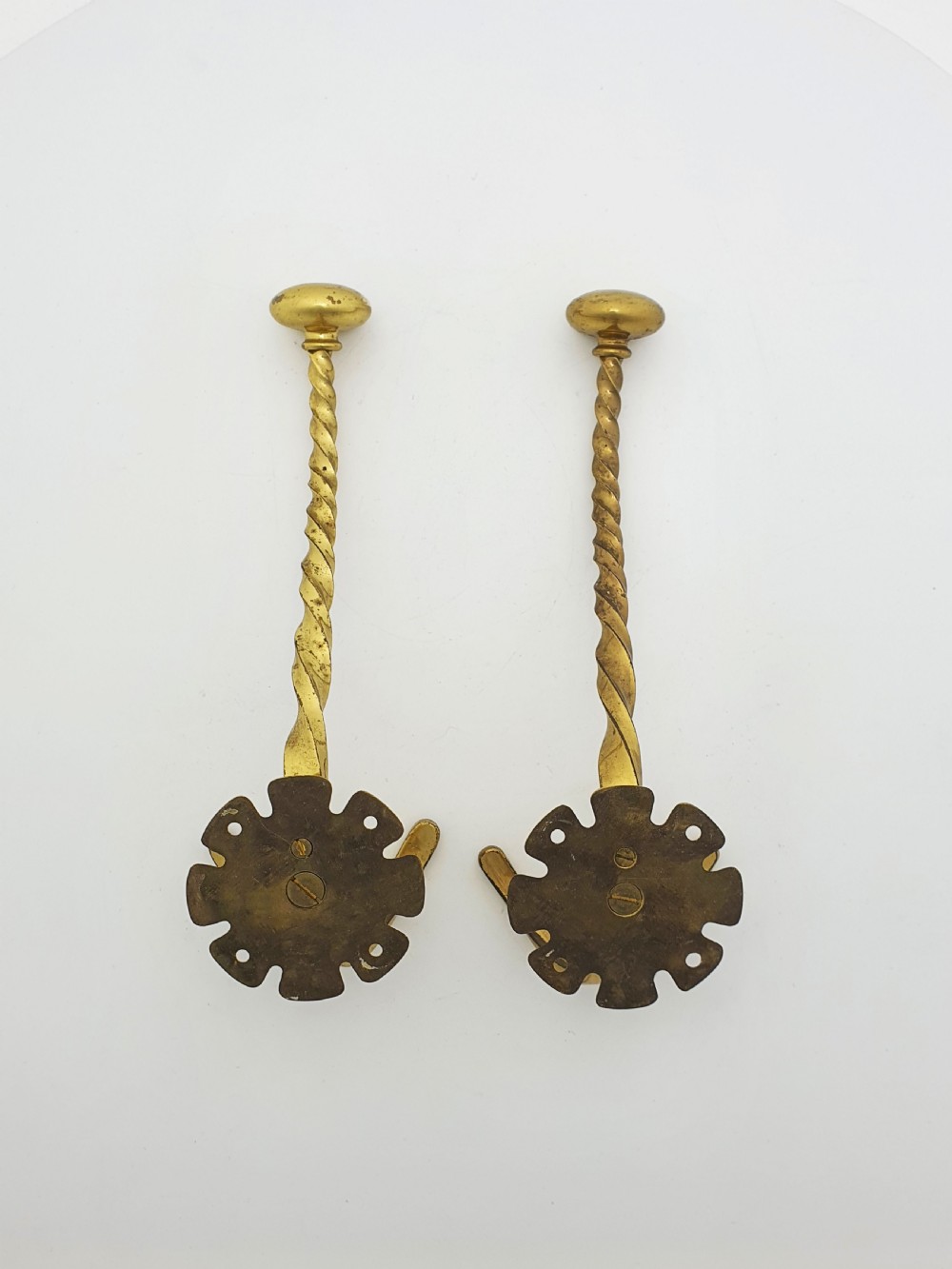 A pair of antique Victorian brass coat hooks with barley twist stems and multi-prong bases. View II