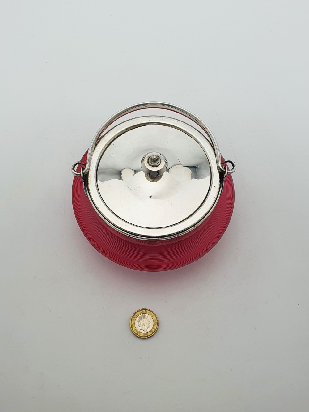 A ribbed cranberry glass biscuit barrel featuring a silver-plated fitted rim, flat lid, and hinged swing handle. View VII
