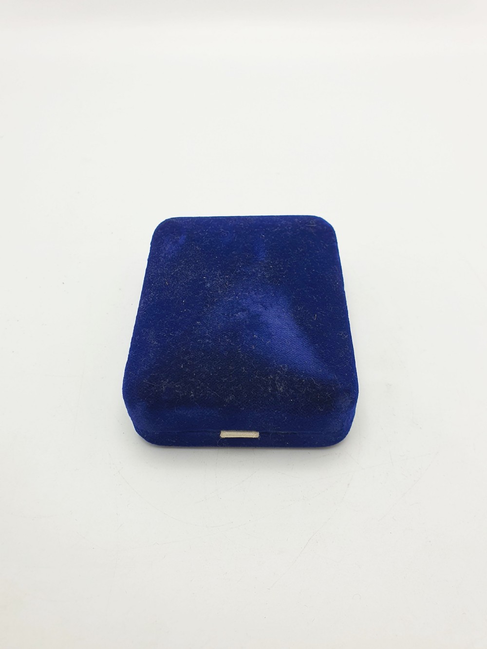 An antique sterling silver vesta case engraved with a golfer and St. Andrews lettering, displayed inside an open blue velvet box. View X