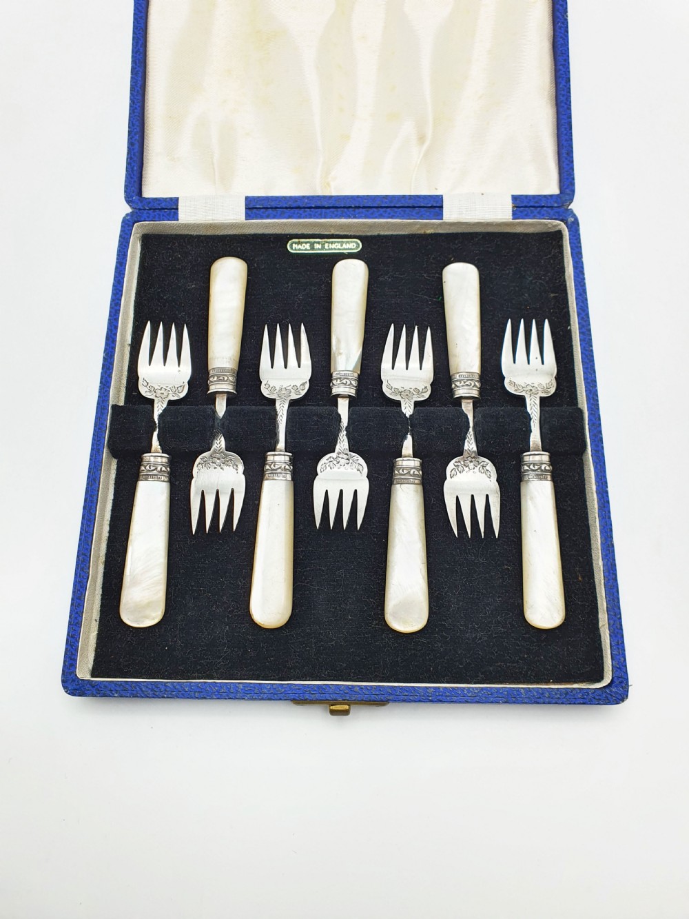 A cased set of six Victorian hors doeuvres forks featuring mother-of-pearl handles and engraved silver-plated tines, presented in a blue fabric-lined box. View III