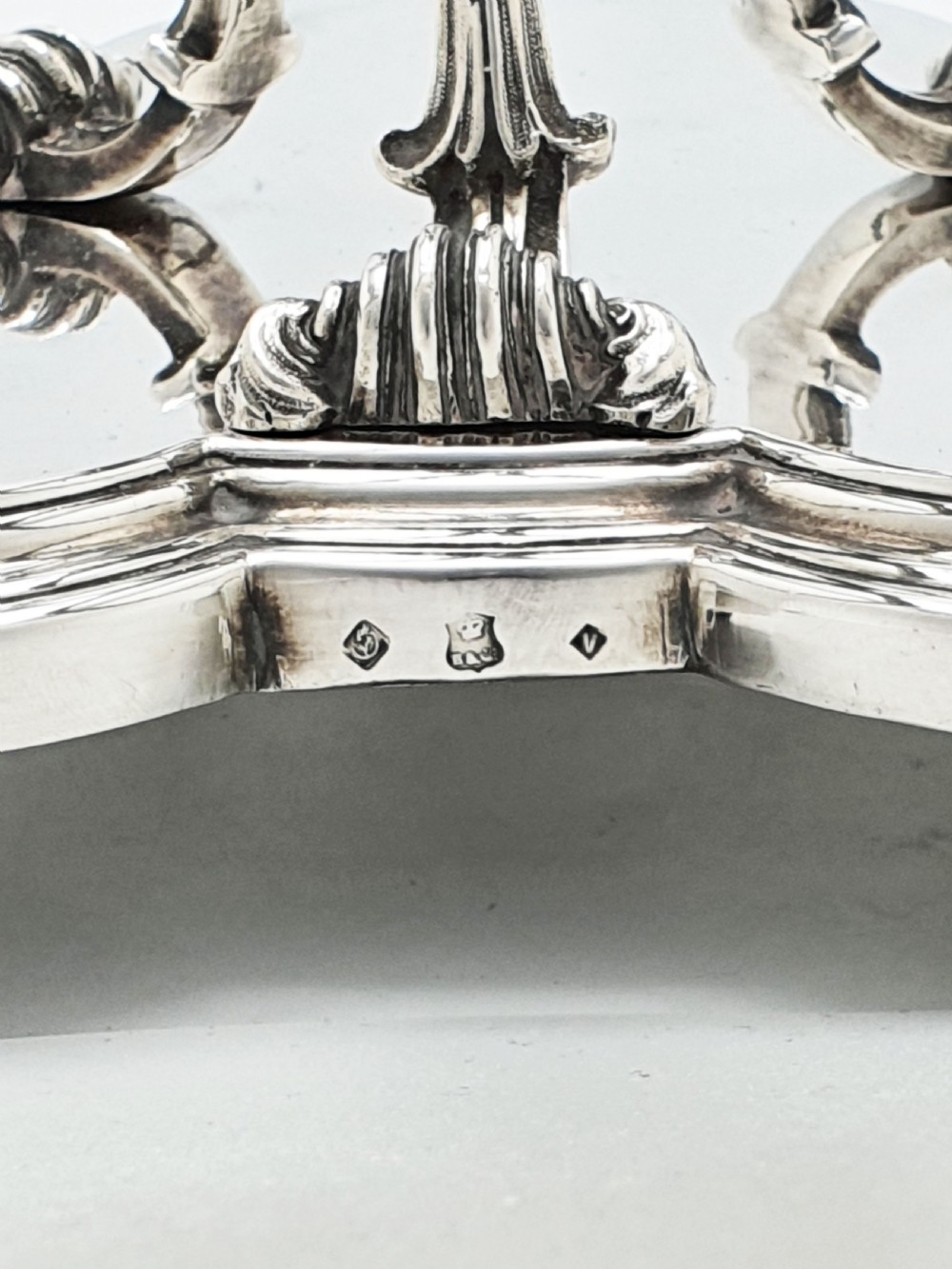 A Victorian silver-plated three-bottle decanter stand holding three clear cut-glass decanters with matching stoppers. View VII