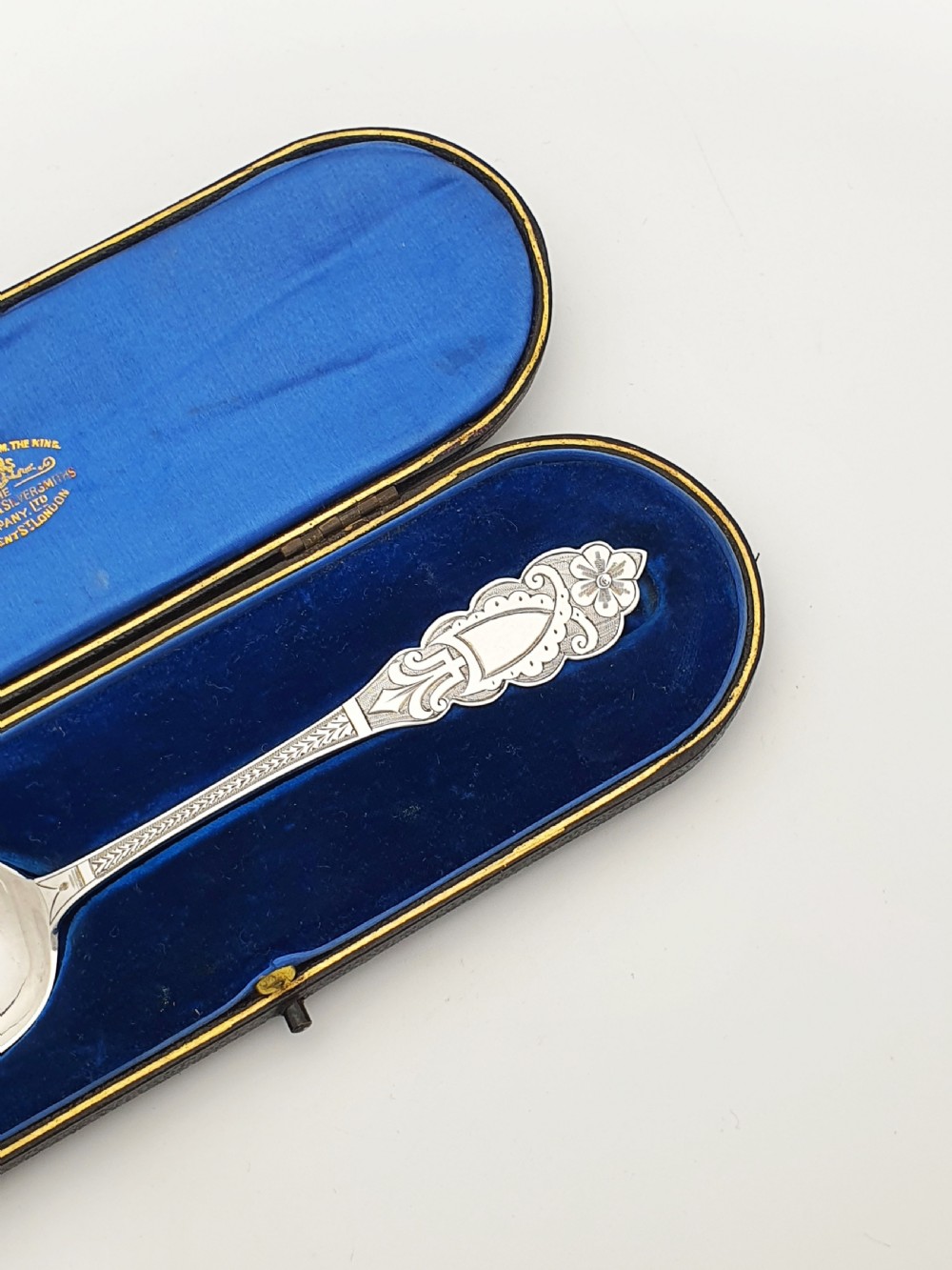 An 1877 Victorian sterling silver presentation spoon with an engraved stag motif inside an open blue velvet presentation box. View VI