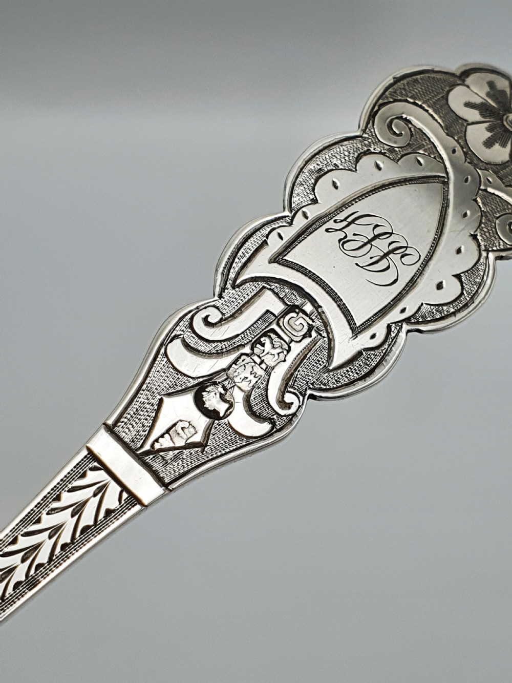 An 1877 Victorian sterling silver presentation spoon with an engraved stag motif inside an open blue velvet presentation box. View VII