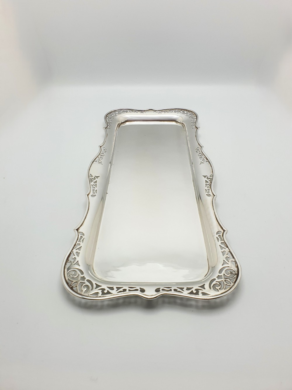A rectangular silver-plated cocktail tray featuring a pierced scrollwork border and a smooth reflective centre. View II