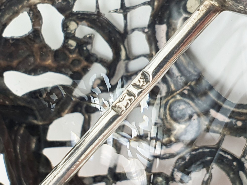 A late Victorian sterling silver and clear glass table bell with a figural handle and ornate pierced silver overlay. View VIII